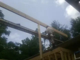 Carpenter setting a ridge beam over a new addition frame — Ice Dam Removal by Roofing Brothers in Valley City