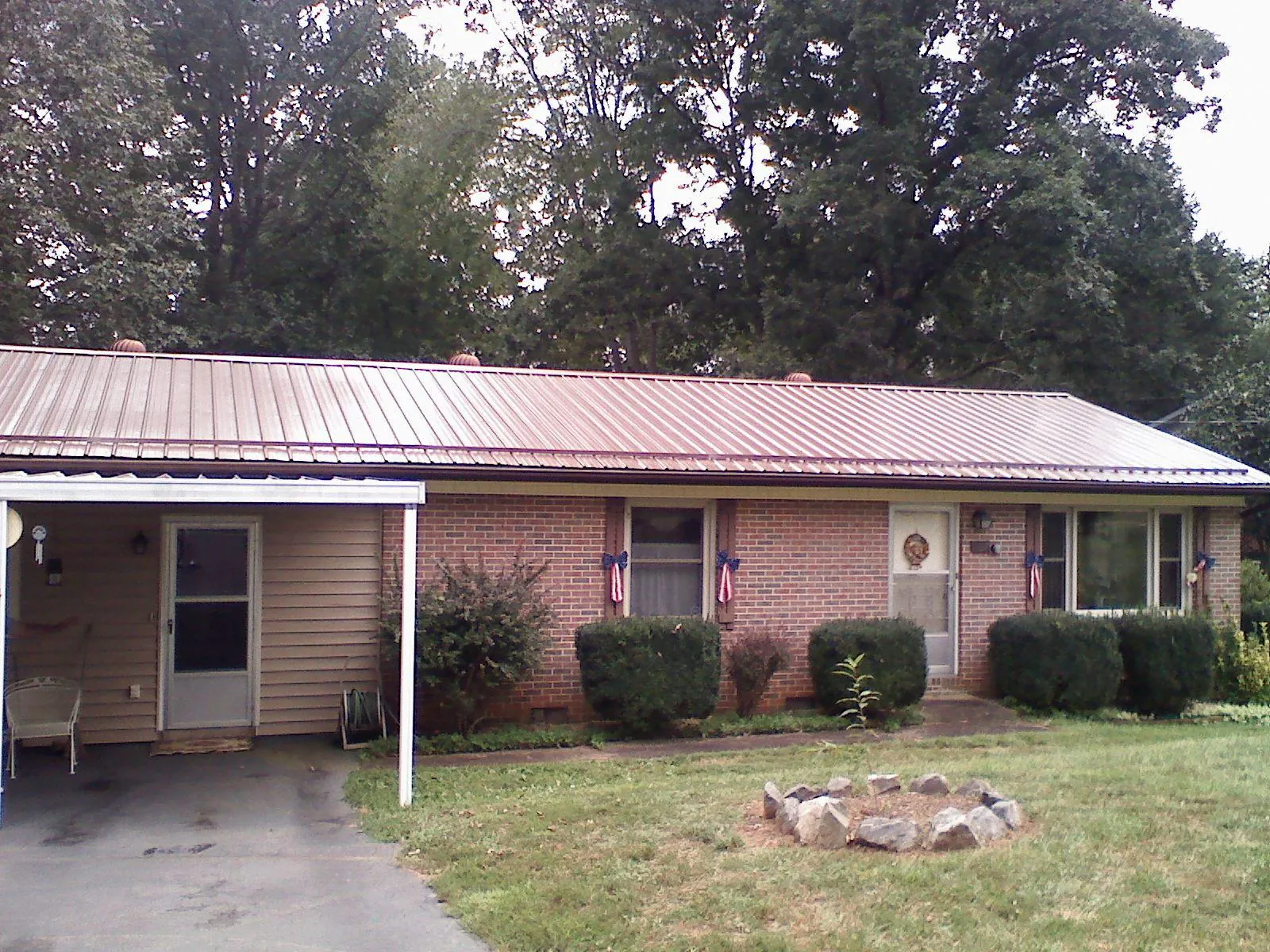 Bronze metal roof and carport on a brick ranch home — Roof Repair work by our crew in Valley City